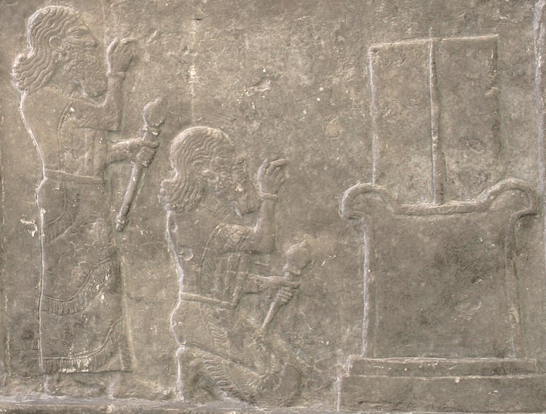Detail of a symbolic base with a cuneiform inscription of Tukulti-Ninurta I, 13th century BCE. From the Temple of Ishtar at Assur, Iraq. Pergamon Museum, Berlin, Germany. Two men were depicted in relief, standing and kneeling holding a mace (representing the Assyrian king Tulkulti-Ninurta I, r. 1243-1207 BCE, in two movements), before a symbolic base with a symbol of the god Nabu of writing (not shown here). The cuneiform inscription mentions the name of the king and the god Nusku (Nuska)