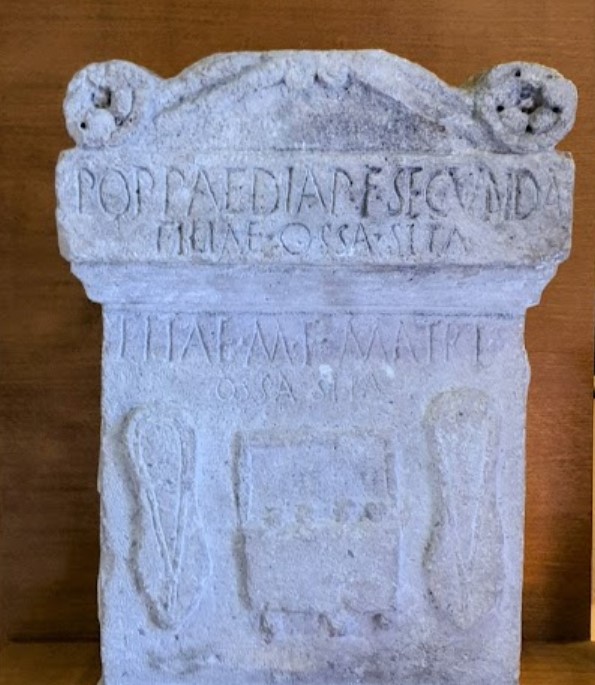 Roman funerary stele. Relief with Roman slippers by lady (socci) and a handbag (bulga) - Museo Lapidario Morsicano, Avezzano